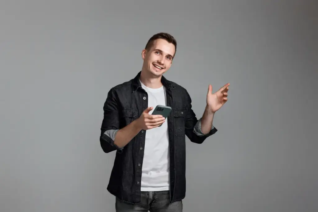 Homem sorrindo, usando o celular