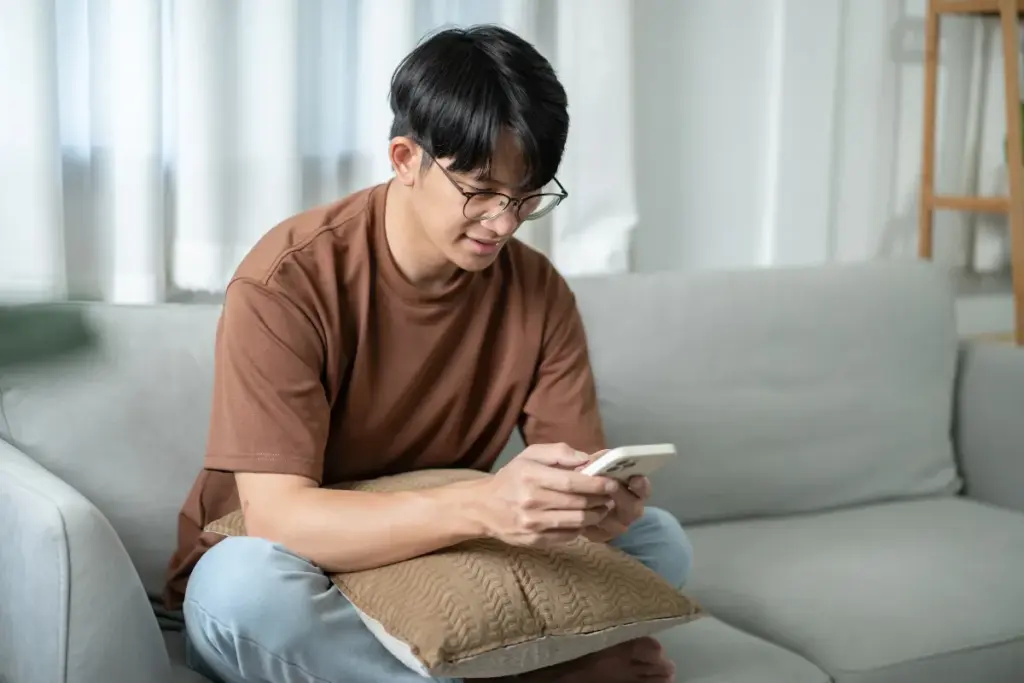 Home sentado, usando o celular