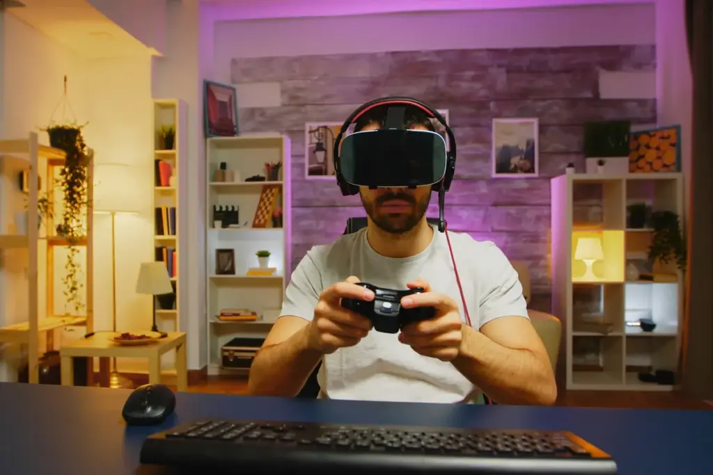 Homem jogando no computador com óculos de realidade virtual e controle, em setup gamer dentro de casa