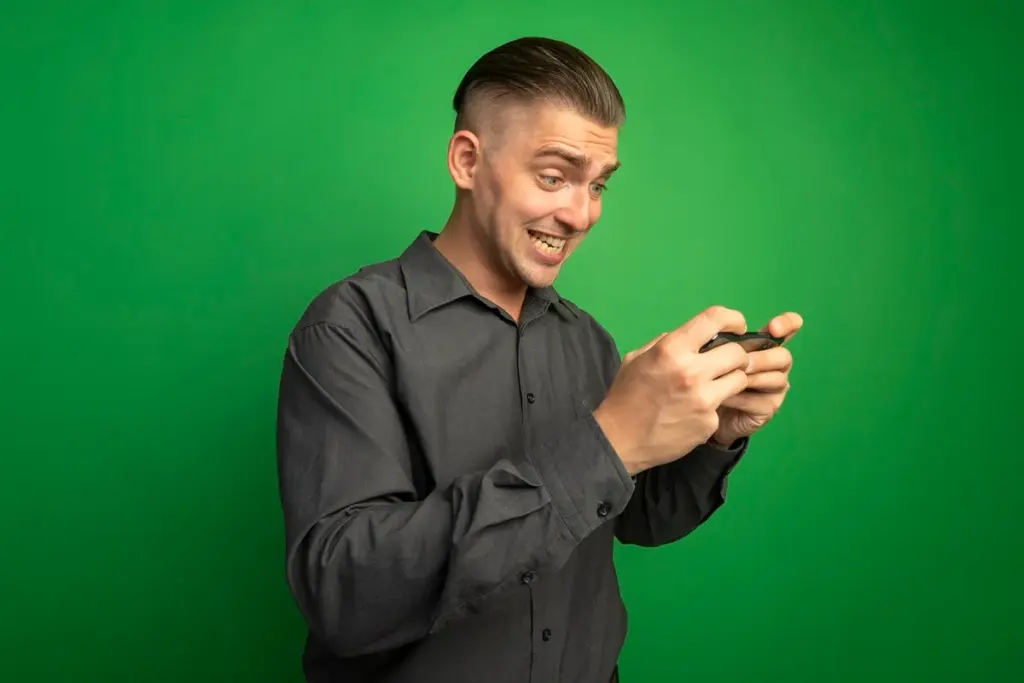 Homem animado usando celular para jogar online com fundo verde