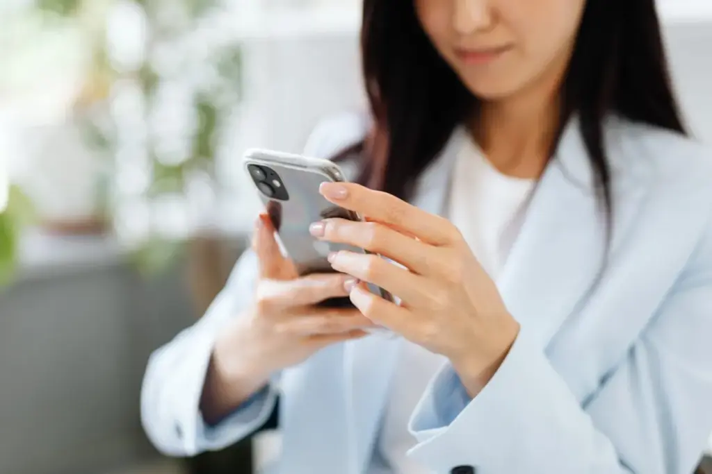 Mulher segurando smartphone e olhando para a tela com foco na navegação