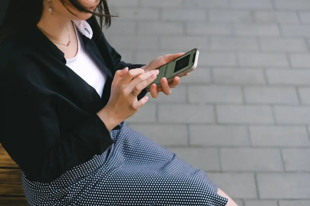 Mulher sentada usando smartphone com uma mão enquanto interage com a tela